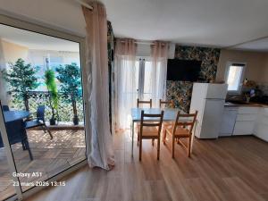 a kitchen and dining room with a table and chairs at Coeur Marina climatisé terrasse parking in Fréjus