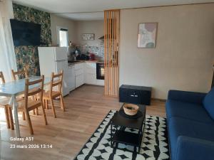 a living room with a blue couch and a table at Coeur Marina climatisé terrasse parking in Fréjus +19 photos