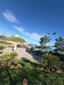 a view of a beach with palm trees and a street light at Refúgio do mar casa de praia em Saquarema in Saquarema