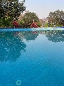 a large pool of blue water with trees in the background at Nadaa Organic Farms in Khammam +9 photos