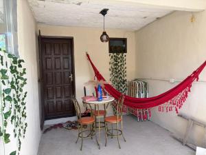 a patio with a table and chairs and a door at Refúgio do mar casa de praia em Saquarema in Saquarema