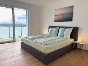a bedroom with a large bed with a large window at Villa 60, luxuriöse Villa mit Pool, Sauna und großem Garten in Gols +24 photos