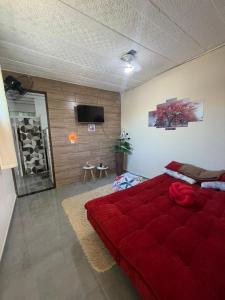a bedroom with a large red bed in a room at Refúgio do mar casa de praia em Saquarema in Saquarema