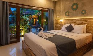 a swan sitting on a bed in a bedroom at Rumah Weda in Ubud