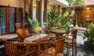 a restaurant with wooden tables and chairs and plants at Rumah Weda in Ubud +13 photos
