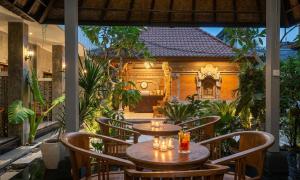 an outdoor patio with two tables and chairs at Rumah Weda in Ubud
