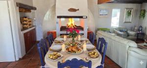 a table with plates of food on it with a fireplace at Verdoesie Jacobsbaai in Jacobs Bay