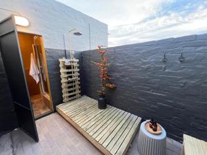 a patio with a wooden platform and a plant on a wall at Die Kuierhuis in Ventersburg