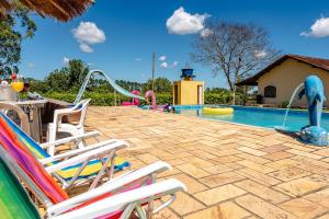 a swimming pool with two chairs and a slide at Paraíso com Piscina, Churrasqueira, Wi-Fi e Karaokê in Ibiúna