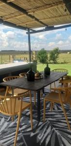 a wooden table and chairs on a patio at Die Kuierhuis in Ventersburg +13 photos