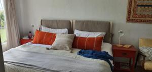 a bedroom with a bed with orange and white pillows at Die Kuierhuis in Ventersburg