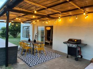 a patio with a table and chairs and a grill at Die Kuierhuis in Ventersburg