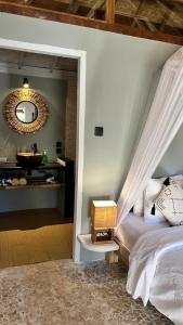 a bedroom with a bed with a mirror and a sink at Café Gili Beach Bungalows in Gili Meno