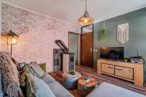 a living room with a couch and a tv at Hisa Lina near Bovec in Srpenica