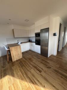 an empty kitchen with a table and a refrigerator at Apartamento Casa Norte in O Grove