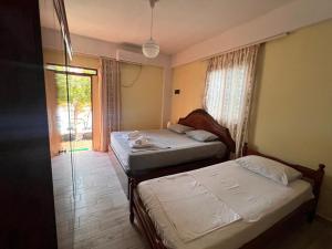 two beds in a room with a window at Room zero of Sea in Borsh