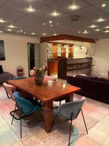 a living room with a wooden table and chairs at Harlingen Garden Apartment in Midlum