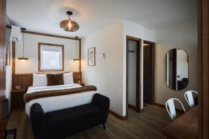 a hotel room with a bed and a mirror at Motel Boutique Hygge - anciennement Aux Portes du Soleil in Baie-Saint-Paul