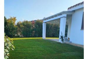 a large white pergola in a yard at Casa Cristina in Costa Rei