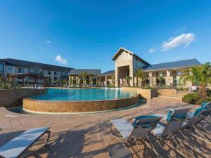 a swimming pool with chairs and a resort at Landing Incredible 2BD Gym in New Caney