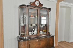 an old wooden cabinet with a clock on top of it at Ferienwohnung Harmony "Residenz" in Leisnig