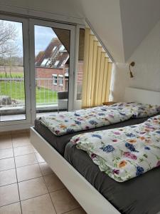 two beds in a room with a large window at Ostseeferienwohnung - Bossert in Kronsgaard +56 photos