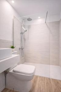 a white bathroom with a toilet and a shower at 22CaLQuEROL Boutique centro suite lux in Puigcerdà