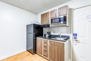 a kitchen with a black refrigerator and a sink at Everstay Living in Dallas