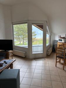 a living room with two large windows and a couch at Ostseeferienwohnung - Bossert in Kronsgaard