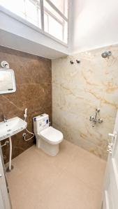 a bathroom with a toilet and a sink at Hotel Sanman in Gulbarga