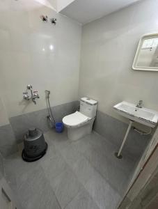 a bathroom with a toilet and a sink at Hotel Sanman in Gulbarga