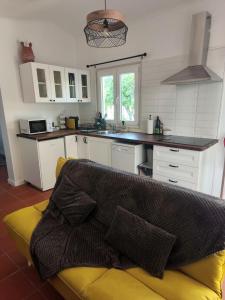 a kitchen with a yellow couch in a kitchen at Oficina do Avô in Villa Nogueira