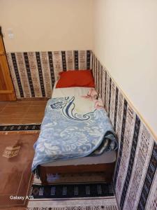 a bed in the corner of a room at Maison authentique in Bou Noura +1 photo