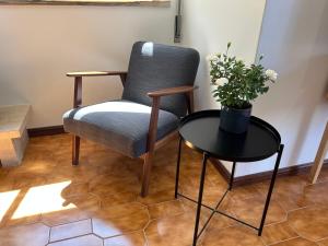 a chair and a table with a vase of flowers at The Urban Terrace in Figueira da Foz