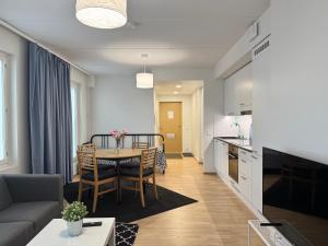 a living room and kitchen with a table and chairs at Easy Stay Rooms & Apartments near Airport in Vantaa