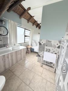a bathroom with a tub and a sink and a toilet at The Hide on 37 Flamingo in East London +44 photos