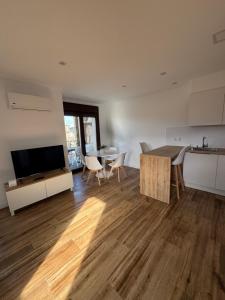 a living room with a kitchen and a table and a dining room at Apartamento Casa Norte in O Grove