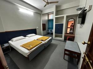 a bedroom with a bed and a television in it at Hotel Sanman in Gulbarga