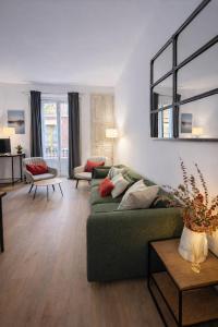 a living room with a green couch and a table at 22CaLQuEROL Boutique centro suite lux in Puigcerdà