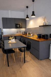 a kitchen with a table and chairs in a kitchen at 22CaLQuEROL Boutique centro suite lux in Puigcerdà