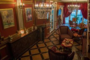 a living room with red walls and chairs and a table at Guest House Vivaldi in Niš