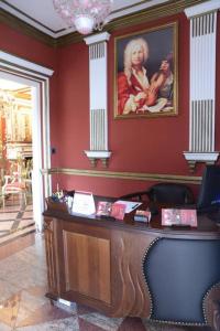 a desk in a room with a painting on the wall at Guest House Vivaldi in Niš