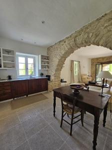 a living room with a table and a stone wall at La Ribaude in Crestet