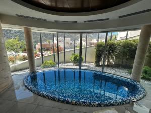 a swimming pool in the middle of a building with windows at One-Bedroom Apartment with Terrace, Sea View, Pool and Spa Lavender Bay Morinj in Donji Morinj
