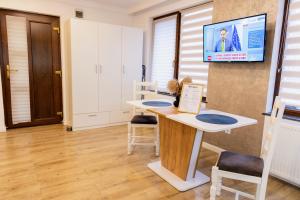 a room with a table and a tv on the wall at Studio Glen in Târgu-Mureş