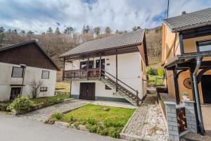 a house with a balcony and a house with a garage at Hisa Lina near Bovec in Srpenica