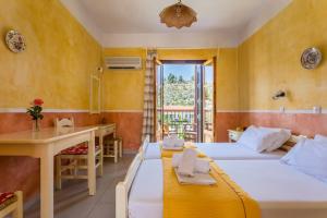 ein Hotelzimmer mit zwei Betten und einem Schreibtisch in der Unterkunft Ageri Studios in Stafylos