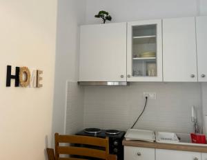 a kitchen with white cabinets and a stove top oven at Ekati in Xylokastro