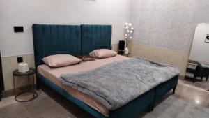 a bed with a blue headboard in a room at SH VILLA Executive in Dhingrānwāli
