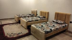 three beds are lined up in a room at SH VILLA Executive in Dhingrānwāli